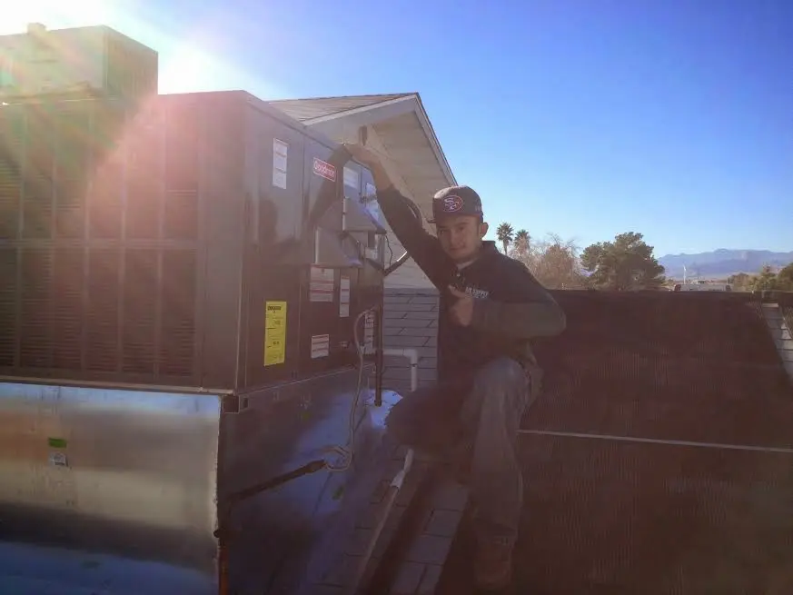 HVAC technician performing HVAC Inspection on a rooftop unit in Grosse Pointe Farms